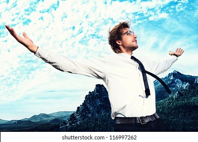 Successful Business Man Standing On A Peak Of The Mountain And Purposefully Looking Away.