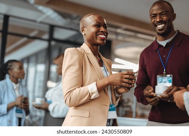 Successful business people networking while enjoying a casual coffee break at a conference. They are exchanging ideas with warm, genuine smiles, promoting a positive work culture and collaboration. - Powered by Shutterstock