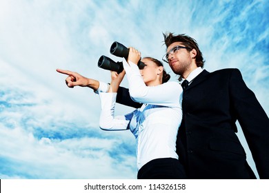 Successful business people  standing over blue sky and purposefully looking away. - Powered by Shutterstock