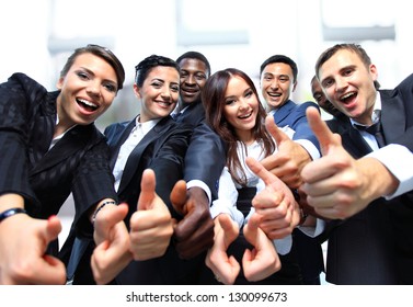 Successful business people with thumbs up and smiling