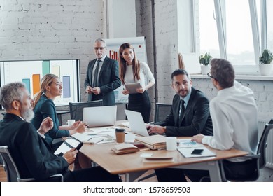 Successful business professionals presenting analytical report while working together with colleagues in the modern office - Powered by Shutterstock