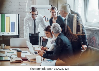 Successful business team analyzing sales while having staff meeting in the board room             - Shutterstock ID 1570227124