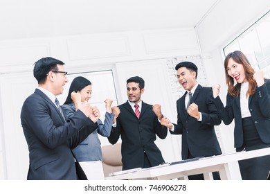 Successful business team celebrating with arms up