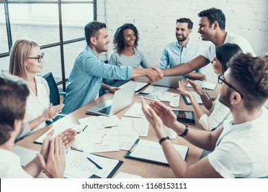 Successful Business Team Congratulating Colleague. Group of Young Happy Collegues Celebrating in Modern Office. Creative Successful Team at Work. Teamwork Concept. Corporate Lifestyle - Shutterstock ID 1168153111