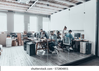 Erfolgreiches Geschäftsteam.  Gruppe junger Unternehmer, die zusammen arbeiten und kommunizieren, während sie an ihren Arbeitsplätzen im Büro sitzen 
