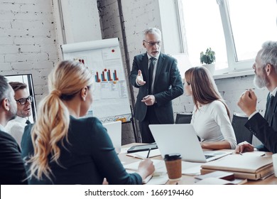 Successful business team listen a man which conducting presentation while filming staff meeting in the board room - Shutterstock ID 1669194460
