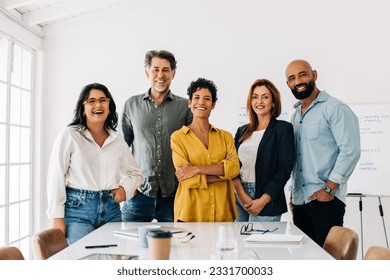 Successful business team standing together in a boardroom. Group of diverse business professionals smiling at the camera. Creative business people having a meeting in an office. - Powered by Shutterstock