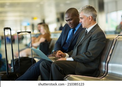 Successful Business Travelers Using Laptop At Airport