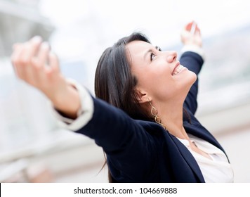 Successful business woman celebrating with arms up