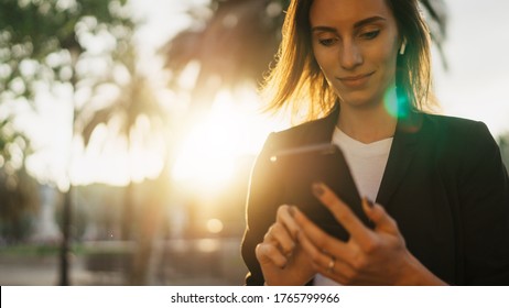 Successful Business Woman Texting On Smartphone Working In Park Barcelona Sun Day, Young Professional Finance Girl Using Mobile Device On Background Sun Flare Outdoors