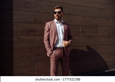 A successful businessman dressed in an expensive suit stands near the office center of his company next to the copy space for your advertising message or advertising content. Young manager man posing  - Shutterstock ID 1777521788