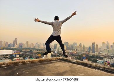 Successful businessman looking at Bangkok City at sunset, hands up - Powered by Shutterstock