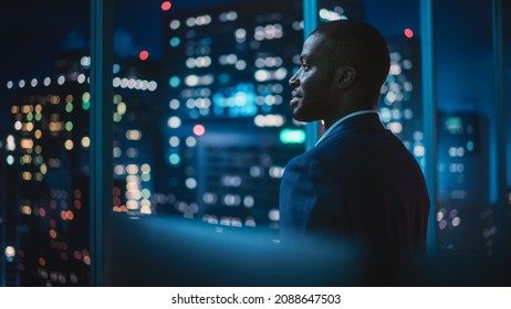Successful Businessman Looking Out of the Window on Late Evening. Modern Hedge Fund Investor Enjoying Successful Life. Urban View with Down Town Street with Skyscrapers at Night with Neon Lights. - Shutterstock ID 2088647503