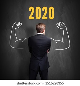 successful businessman standing in front of a blackboard with 2020 written on it - Shutterstock ID 1516228355