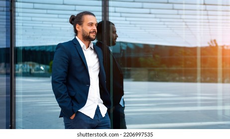 Successful Businessman In Suit With Beard Standing Near Office Building Confidently Looking Away. Hispanic Male Business Person Side View Portrait. Web Banner Free Space. Modern Business People