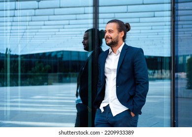 Successful Businessman In Suit With Beard Standing Near Office Building Confidently Looking Away. Hispanic Male Business Person Side View Portrait. Free Space. Modern Business People