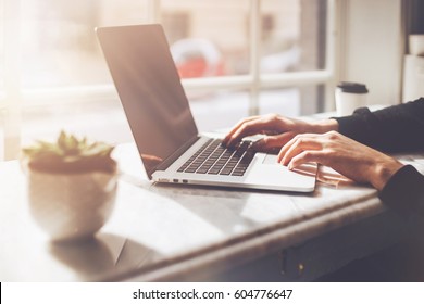 Successful businessman working in cafe during coffee break, Closeup of man's hands using modern laptop in modern stylish cafe - Powered by Shutterstock