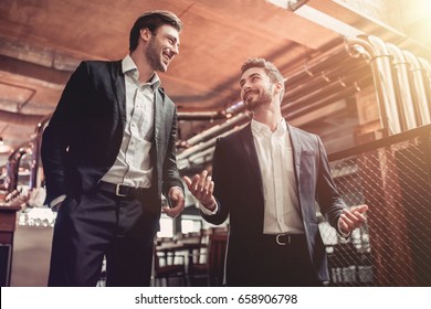 Successful businessmen are communicating in bar and smiling. Discussing the latest news. - Powered by Shutterstock