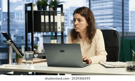 Successful businesswoman analyzes data and market trends on laptop, maximizing income, optimizing expenses and ensuring the company budget. Success story in a global business landscape. Camera A. - Powered by Shutterstock