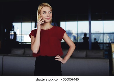 Successful Businesswoman Calling With Mobile Phone To Her Colleague Which She Waits In Luxury Restaurant Interior,confident Female Talking On Cell Telephone With Partner While Standing In Modern Space