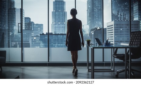 Successful Businesswoman in Stylish Dress Looking out of the Window at Big City in Downtown Area. Confident Female CEO Working on Financial Projects. Manager at Work Planning Marketing Campaign. - Shutterstock ID 2092362127