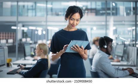 Successful Businesswoman in Stylish Dress Using Tablet Computer, Standing in Modern Diverse Office Working on Financial, Business and Marketing Projects. Portrait of Beautiful Asian Manager. - Powered by Shutterstock