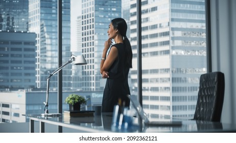 Successful Businesswoman in Stylish Dress Working on Laptop, Looking out of the Window at Big City. Confident Female CEO Analyze Financial Projects. Manager at Work Planning Marketing Campaign. - Shutterstock ID 2092362121