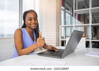 successful businesswoman at work with laptop with hand gesture - Shutterstock ID 2242128087