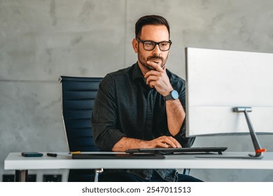 Successful busy professional business man working on computer sitting at desk.