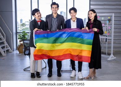 Successful Company With Happy Workers Group Of Asian Business People With Diverse Genders (LGBT) Celebrate LGBT Freedom And Support With LGBT Flag In The Meeting Room At Office