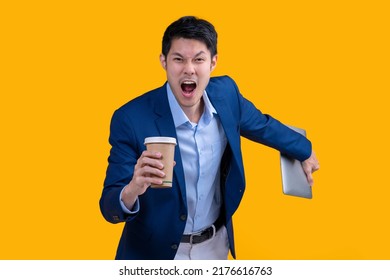 Successful complete Active Happiness asian cheerful exited young businessman running action while holding tablet and coffee mug in isolated on studio yellow colour background