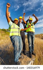 Successful Construction Workers With Arms Outstretched Outdoors