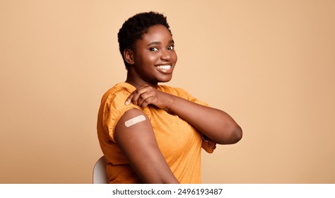 Successful Coronavirus Vaccination. Black Woman Showing Vaccinated Arm After Covid-19 Vaccine Injection Shot Posing Smiling To Camera On Beige Background. Corona Virus Immunization Concept. Panorama - Powered by Shutterstock