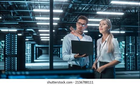 Successful Data Center IT Specialist Using Laptop Computer. Server Farm Cloud Computing Facility with System Administrator Working. Data Protection Engineering Network for Cyber Security.