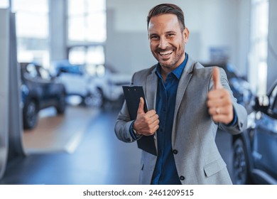 Successful deal in a car showroom! Handsome male car salesman working in the showroom. Salesperson at car dealership selling vehichles.  - Powered by Shutterstock