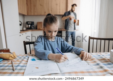 a successful and diligent first grader does her homework at home at the kitchen table