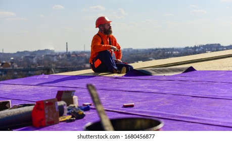 Successful Engineer. Worker Special Protective Work Wear. New Roof Under Construction Residential Building. Builder Use Hammer. Professional Master Repair Roof. Flat Roof Installation. Roofing Felt.