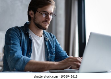 Erfolgreicher Unternehmer, der bei der Prüfung von Informationen auf seinem Laptop-Computer zufrieden lächelnd