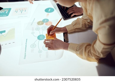 Successful executive Director showing te finance growth statistics of company to a group of Investors over meeting room interior. Illuminated table with data Analysis. Concept of investment, startup - Shutterstock ID 2307520835
