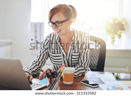 Successful female entrepreneur with a new online business working from home on her computer typing in data ストックフォト © 
