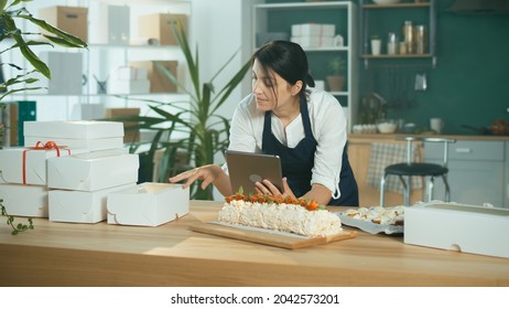 Successful Female Small Business Owner Prepares A Customer Order. Modern Designer Kitchen. Confectionery And Favorite Business. Organization Of Work In The Field Of Delivery. Startup.