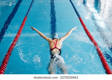 Successful female swimmer swimming in the pool. A professional athlete is determined to win the championship - Powered by Shutterstock