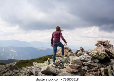 Successful Fitness Woman Climbing Through The Rocks To The Top Of The Mountain