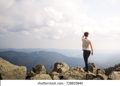 Successful Fitness Woman Climbing Through The Rocks To The Top Of The Mountain