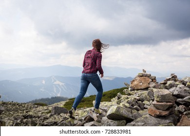 Successful Fitness Woman Climbing Through The Rocks To The Top Of The Mountain