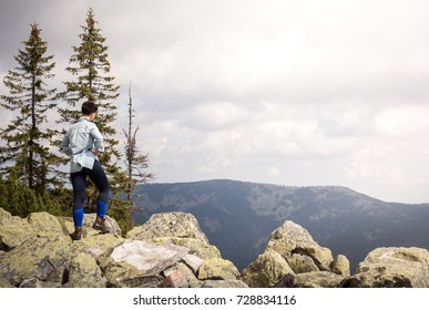 Successful Fitness Woman Climbing Through The Rocks To The Top Of The Mountain