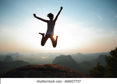 Successful Freedom Woman Jumping On Sunrise Mountain Top