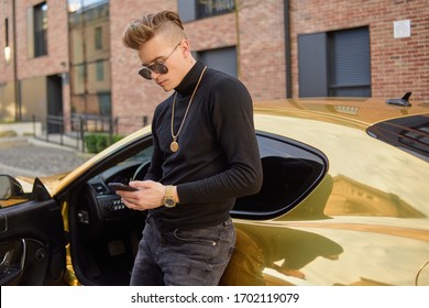 Successful freelancer, a man earns by phone, a man in a golden car, in gold chains. A rich man meets on the Internet. Man with glasses.