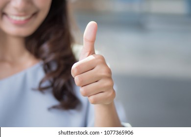 successful girl pointing thumb up sign gesture; portrait of cheerful smiling woman pointing up approving, yes, ok, good, thumb up gesture; asian woman young adult model - Shutterstock ID 1077365906