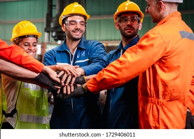 Successful group portrait of smart creative industry technician engineer wearing uniform and safety helmet join hand together in factory station background. Industry, teamwork and partnership concept. - Shutterstock ID 1729406011